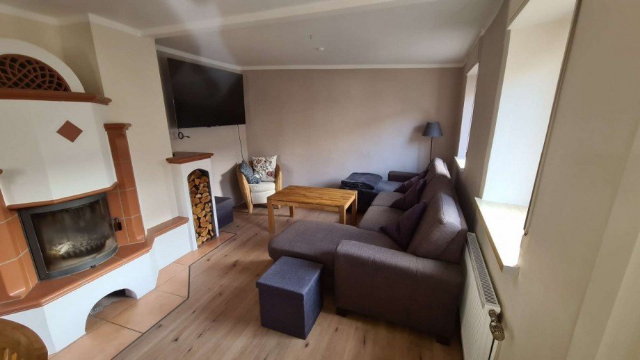 Blick Wohnzimmer mit Kachelofen EG im Haupthaus Renditeobjekt Hargesheim